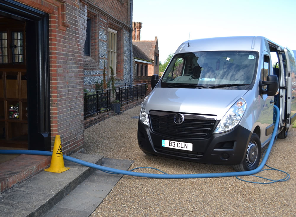 Truck mounted carpet cleaning equipment hose into house